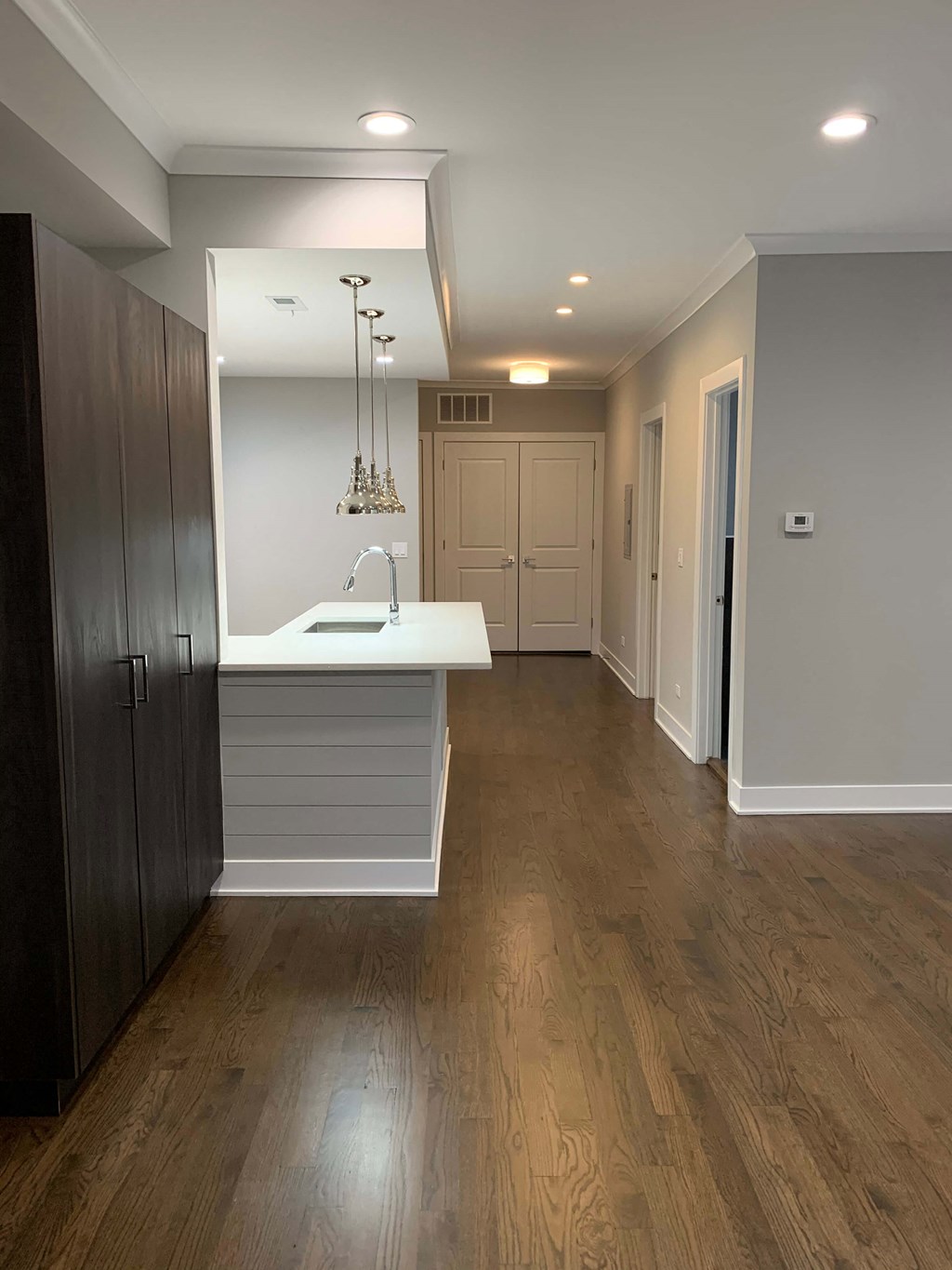 a kitchen with a sink and a counter top in a empty room