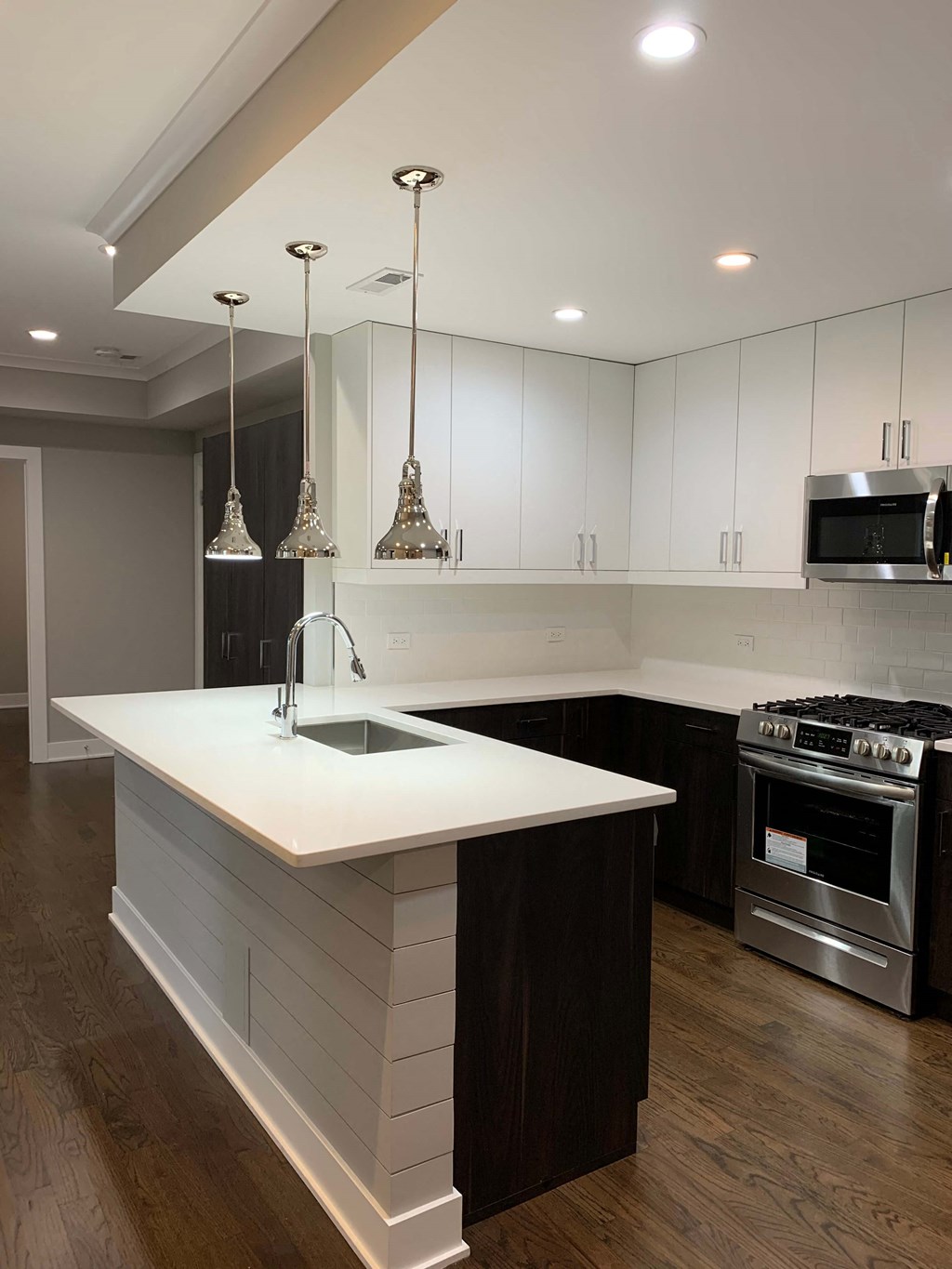 a large white kitchen with stainless steel appliances