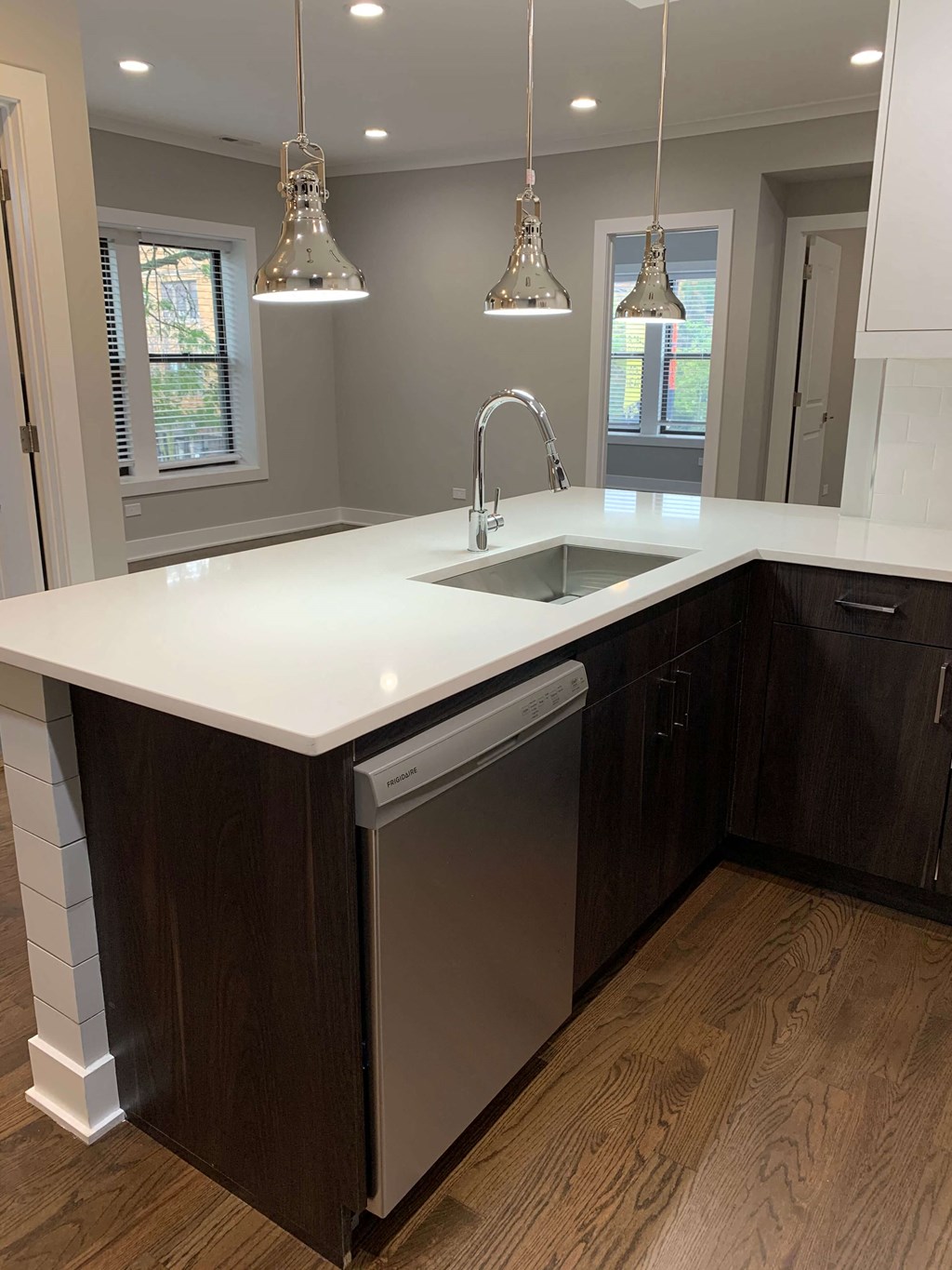 a white counter top in a kitchen with a sink