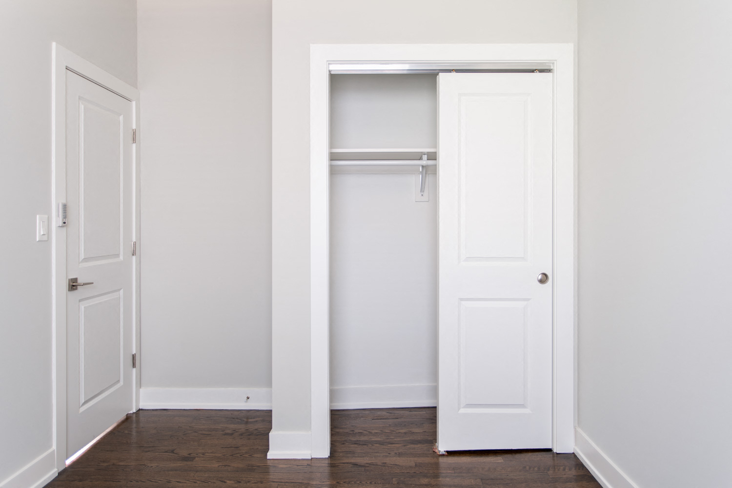 an empty room with a closet and a door open