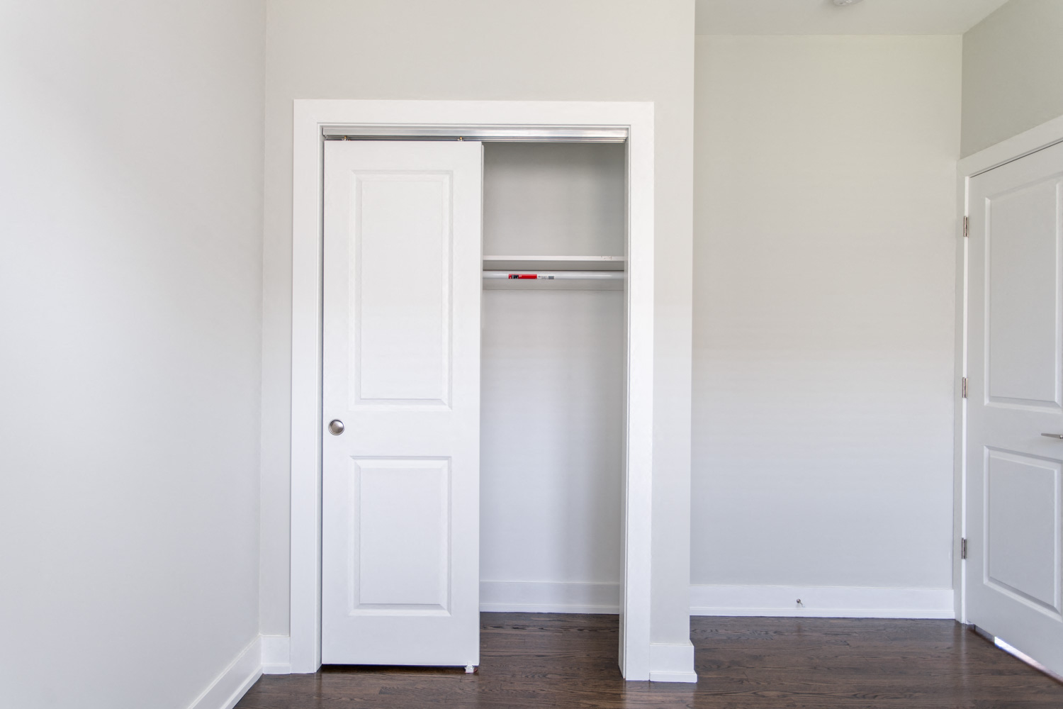 an empty room with a closet and a white door