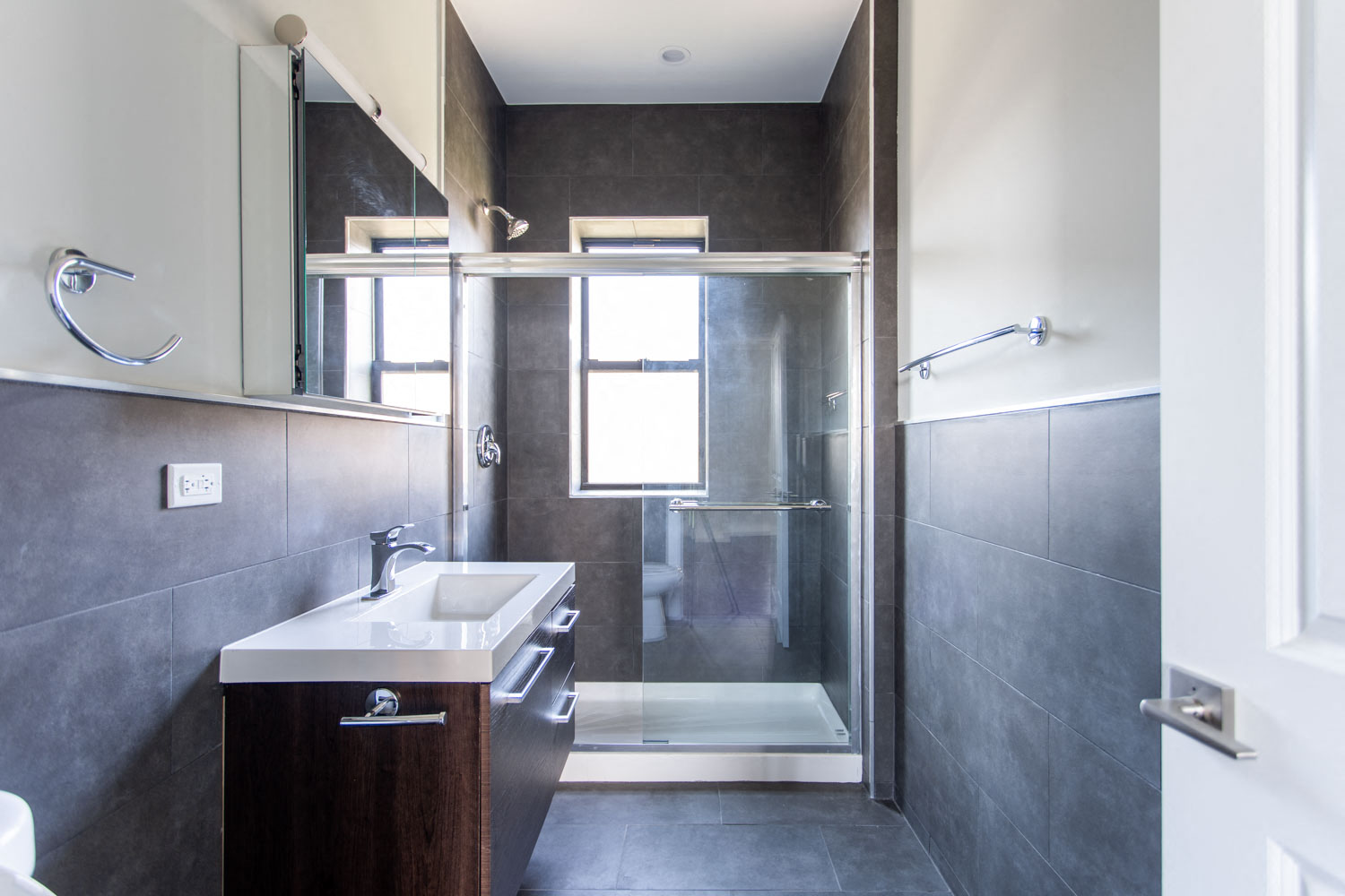 a bathroom with a shower and a sink and a mirror