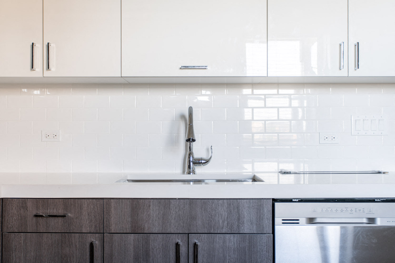 a white kitchen with a sink and white cabinets