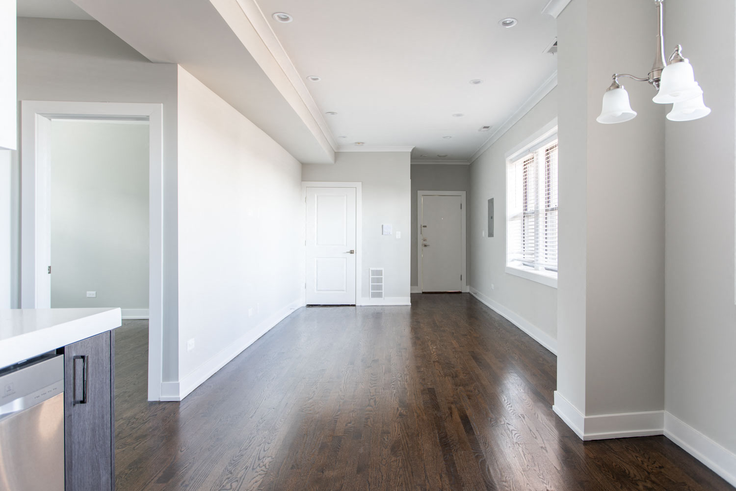 an empty living room with white walls and wood floors