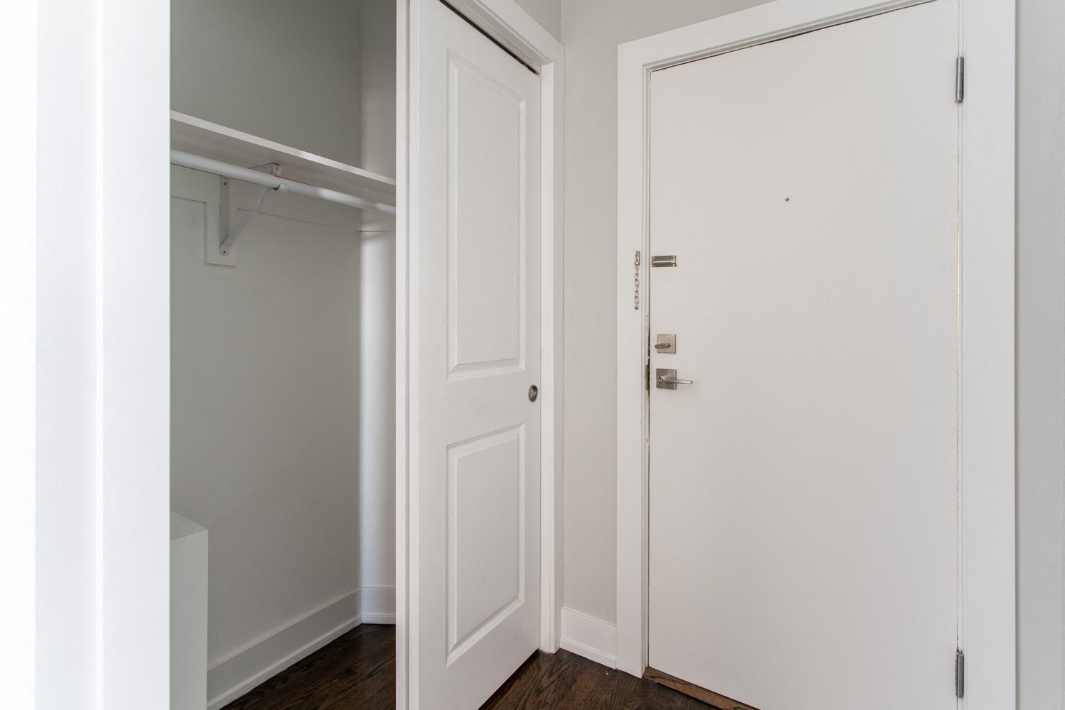 a closet with white doors and a white door to a closet