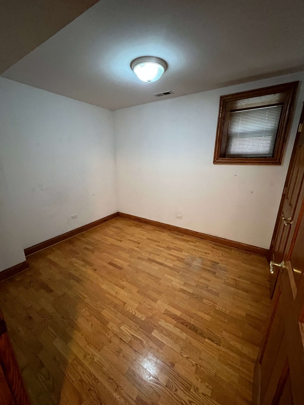 a empty room with wooden floors and a window