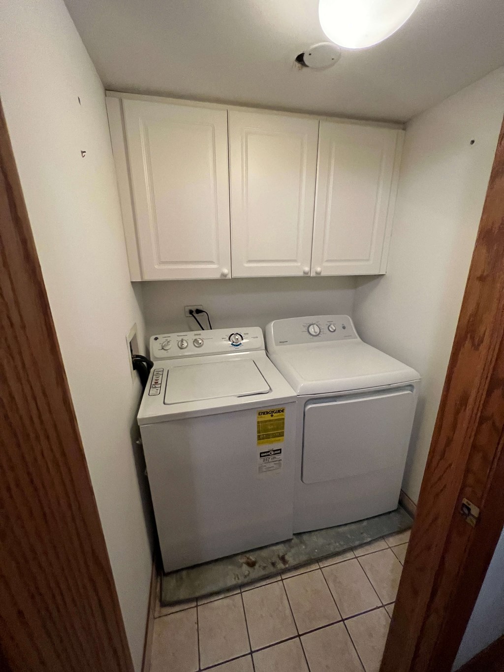 a washer and dryer in a laundry room with white cabinets