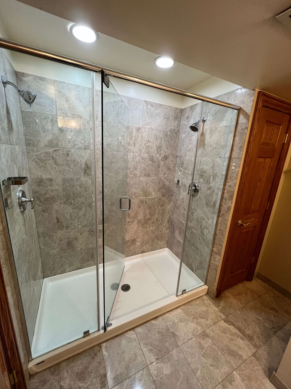 a large shower with a glass door in a bathroom