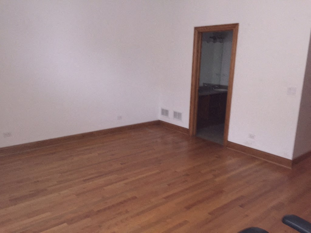 a room with wooden floors and a door to a closet