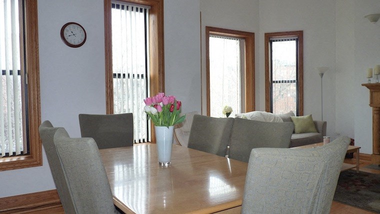 a dining room with a wooden table with flowers on it