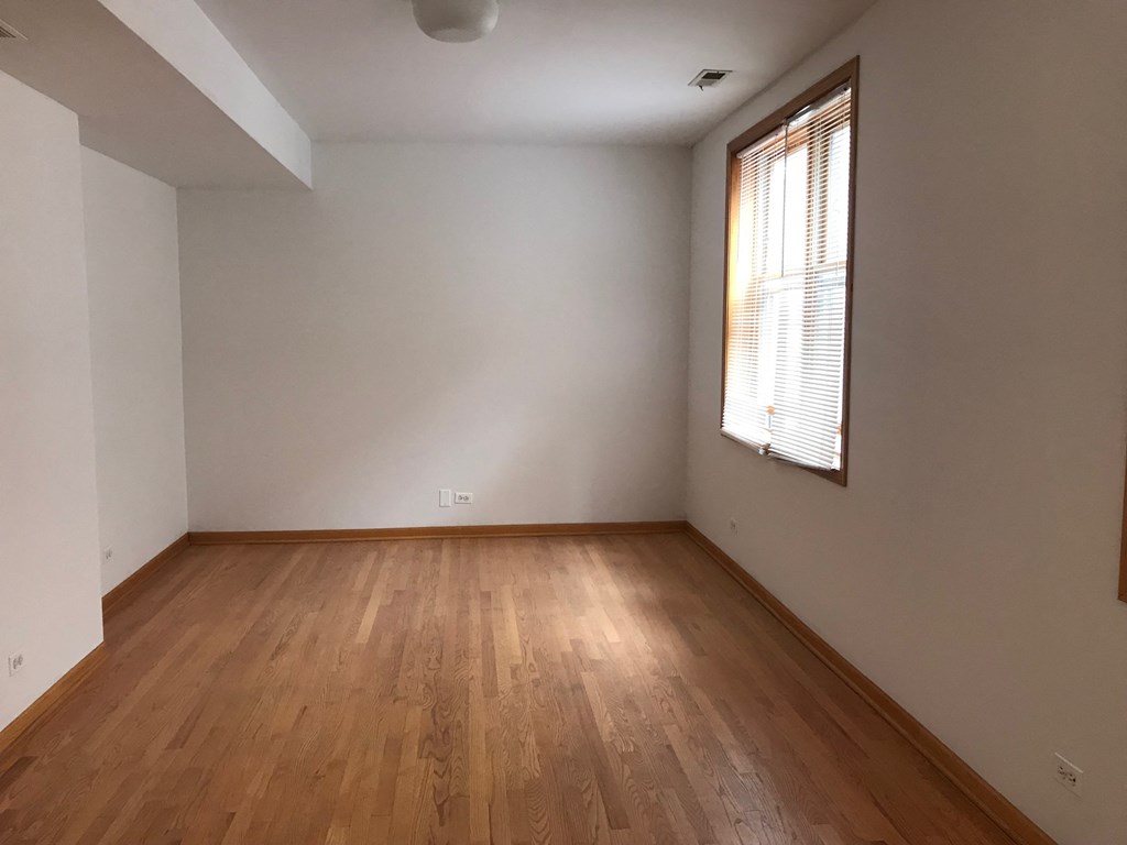 an empty room with wooden floors and a window