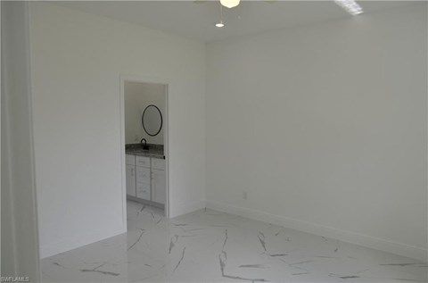 a white room with a sink and a mirror in it