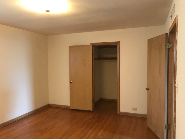 an empty room with a wooden floor and a door