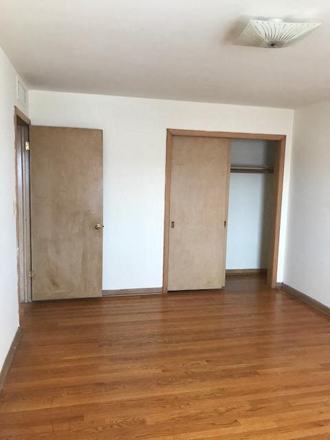 an empty room with wooden floors and two doors