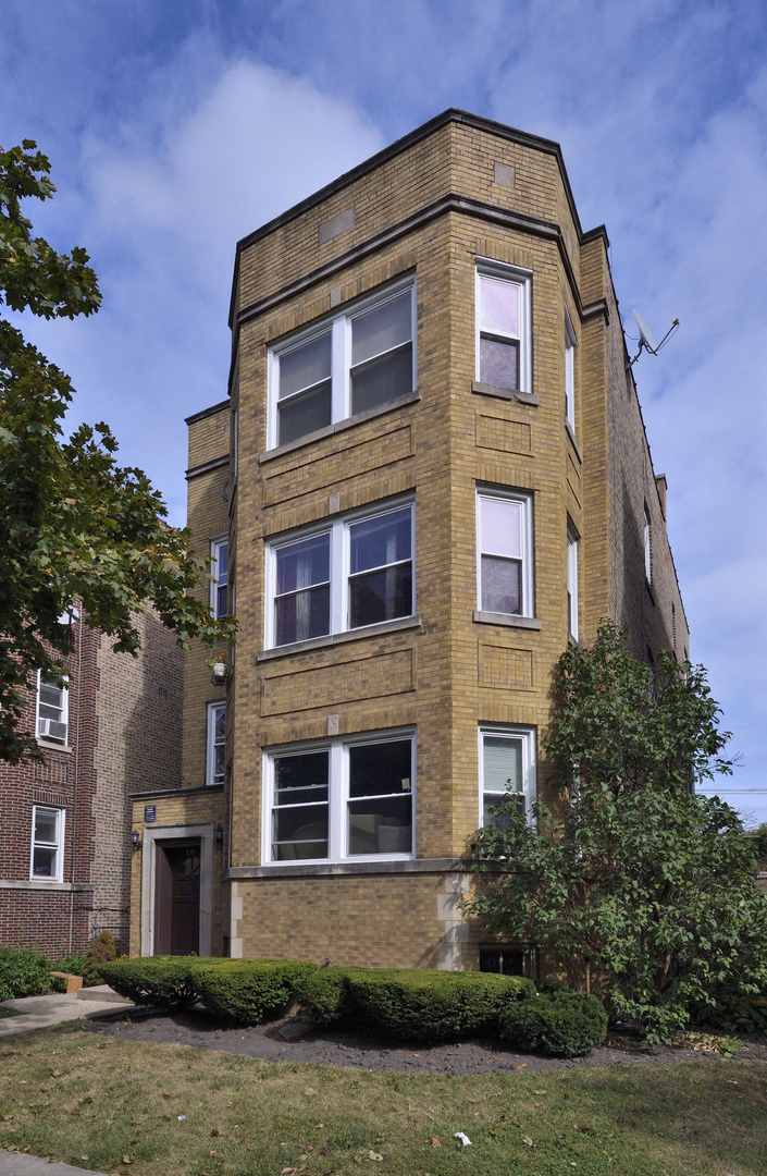 a tall brick apartment building with a blue sky