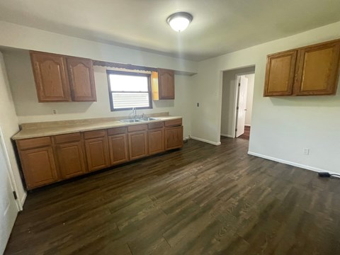 A kitchen with wooden cabinets and a window.