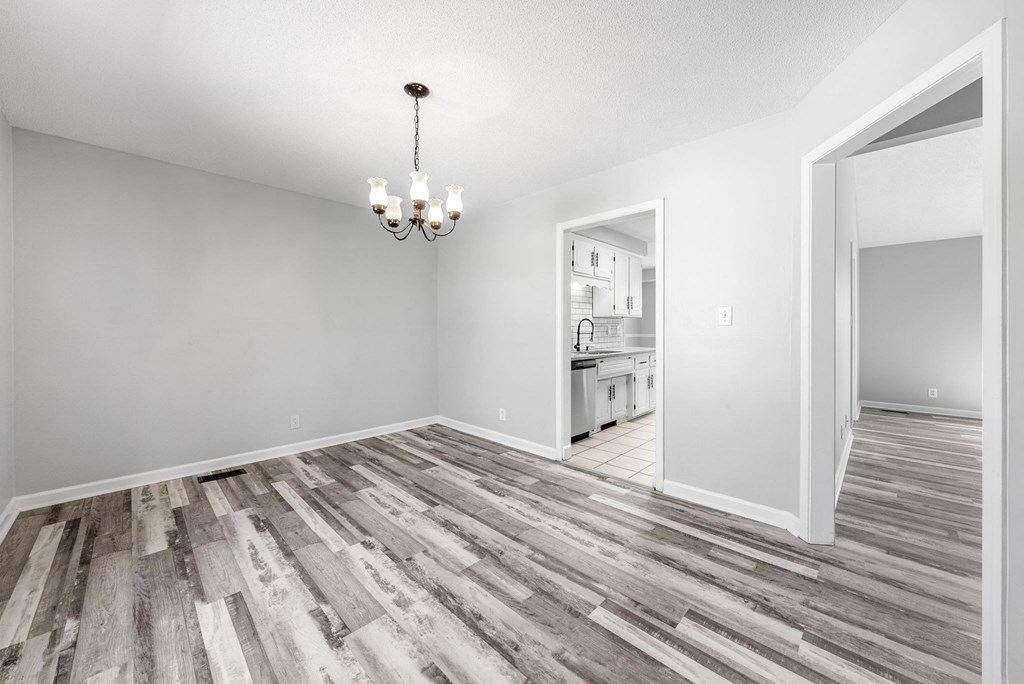 the living room and dining room with a view of the kitchen in a new home