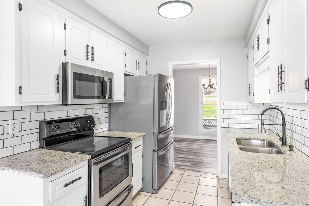 a kitchen with stainless steel appliances and white cabinets