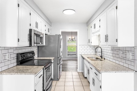a kitchen with white cabinets and stainless steel appliances