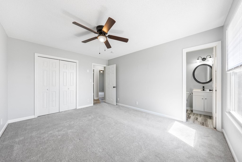 an empty living room with a ceiling fan