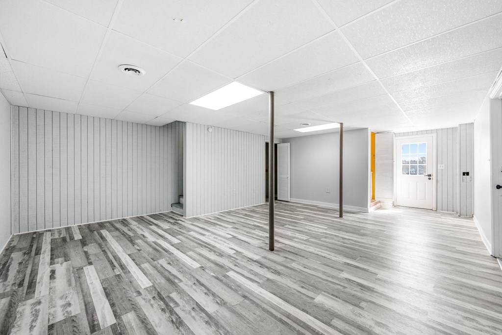 an empty room with white walls and wood floors