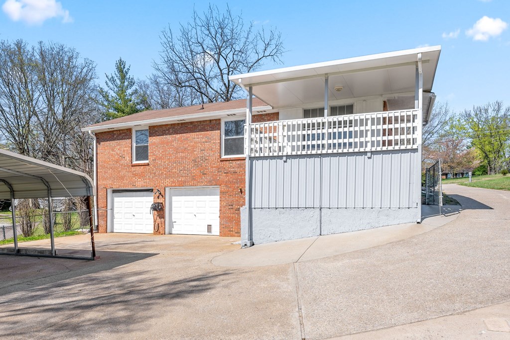 the front of a brick house with two garage doors