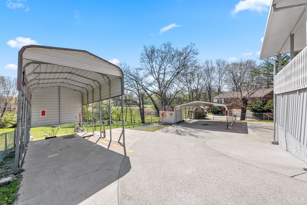 the entrance to a parking lot with a building and a gate