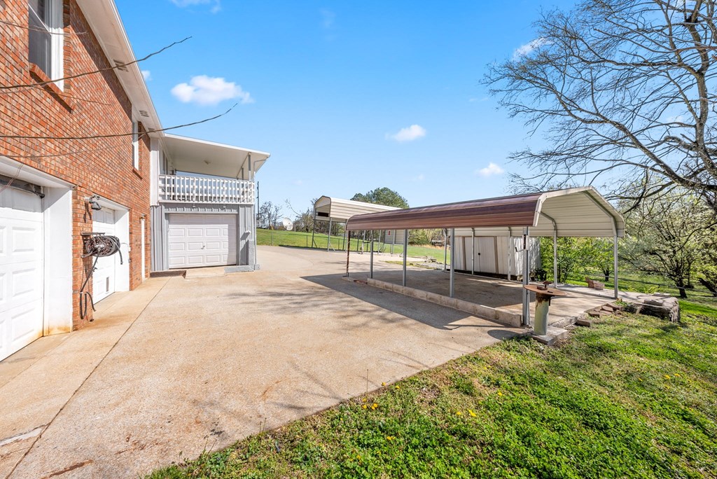 the driveway of a house with a garage and a shed on the side