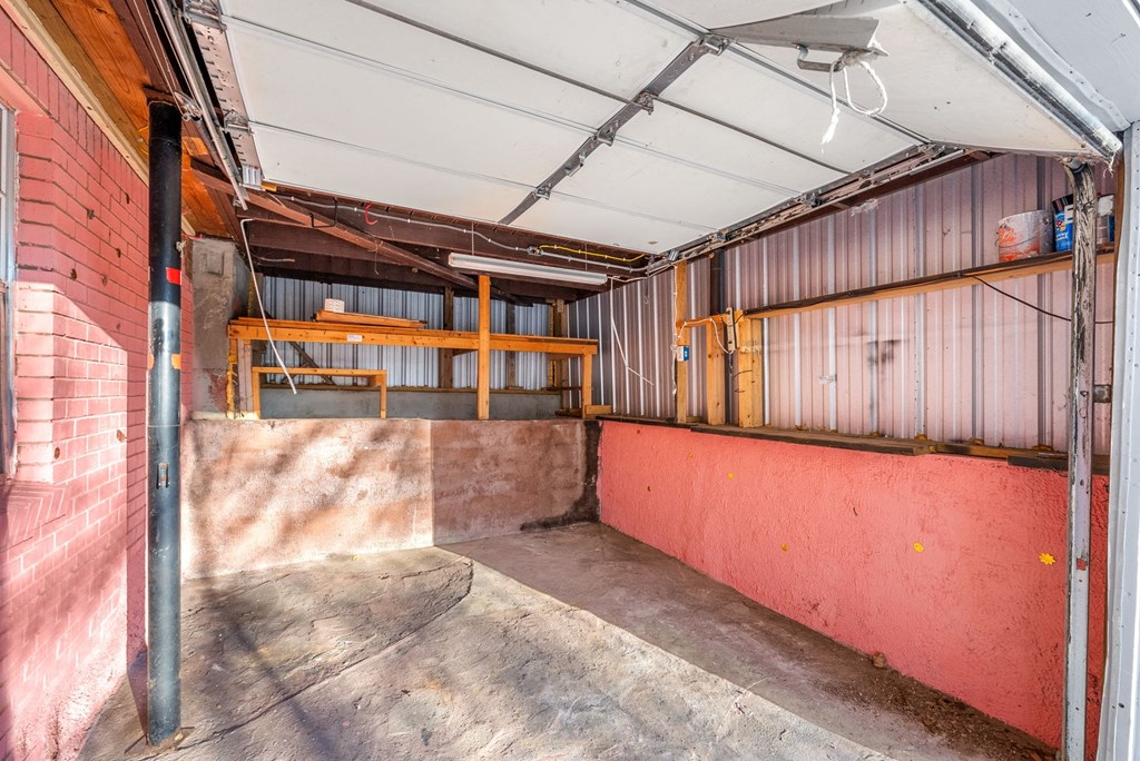 the inside of a garage with a red wall and a pink wall with a wall