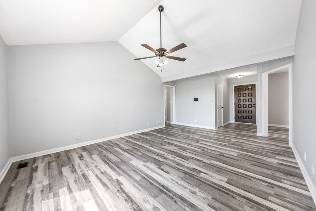 the living room and dining room in a new home with a ceiling fan