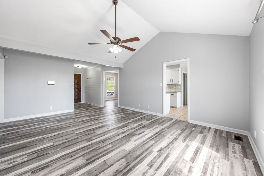 a living room with grey walls and a ceiling fan
