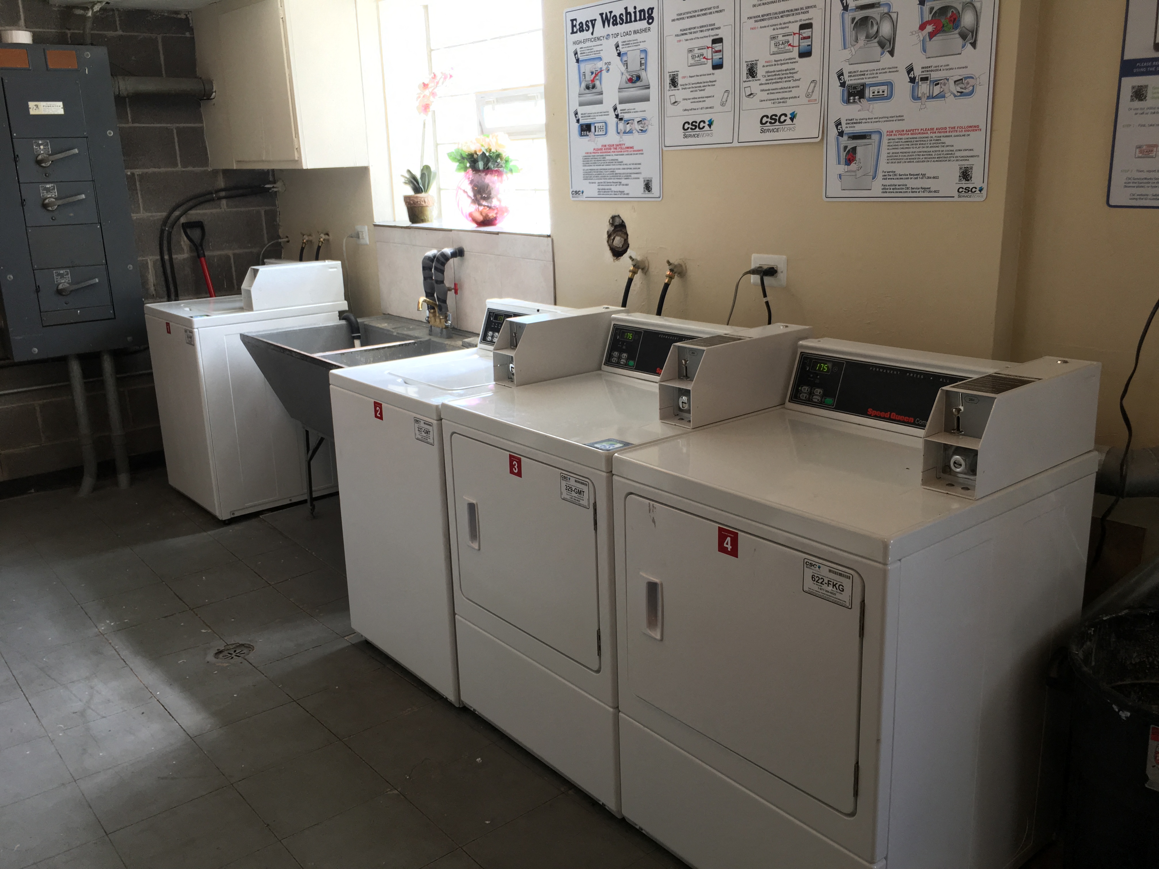 three washers and dryers in a laundry room
