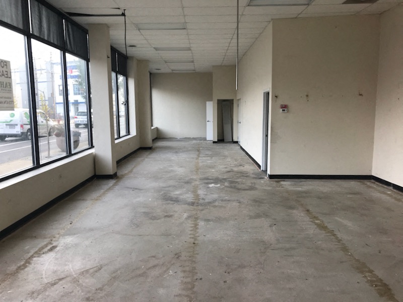 Empty office space with concrete floors and white walls.