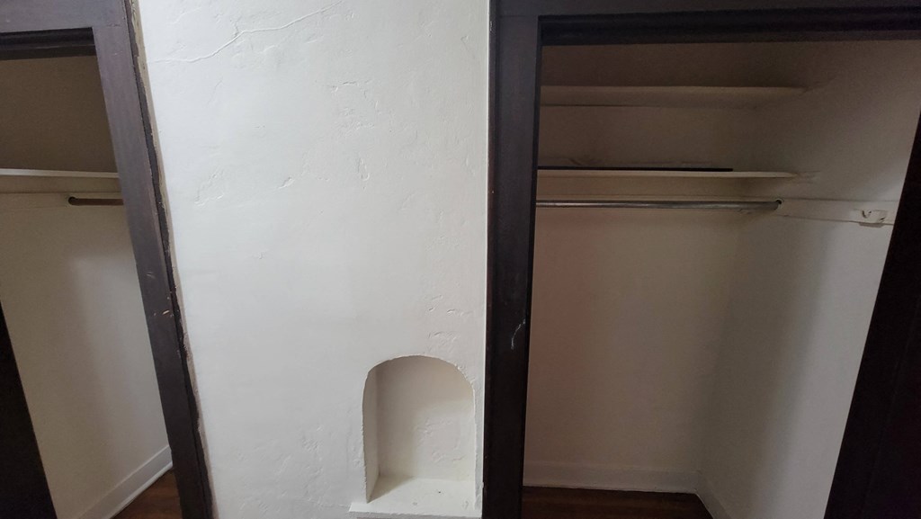 the closet in the bathroom is empty and the door is open