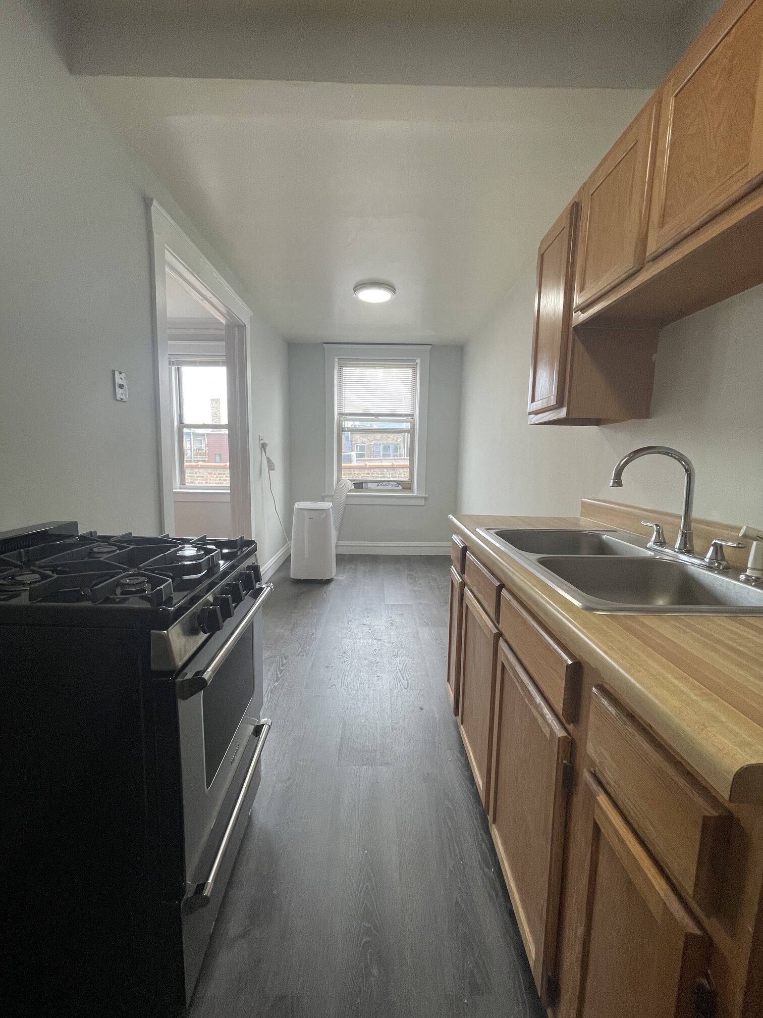 a kitchen with a stove and a sink and a window