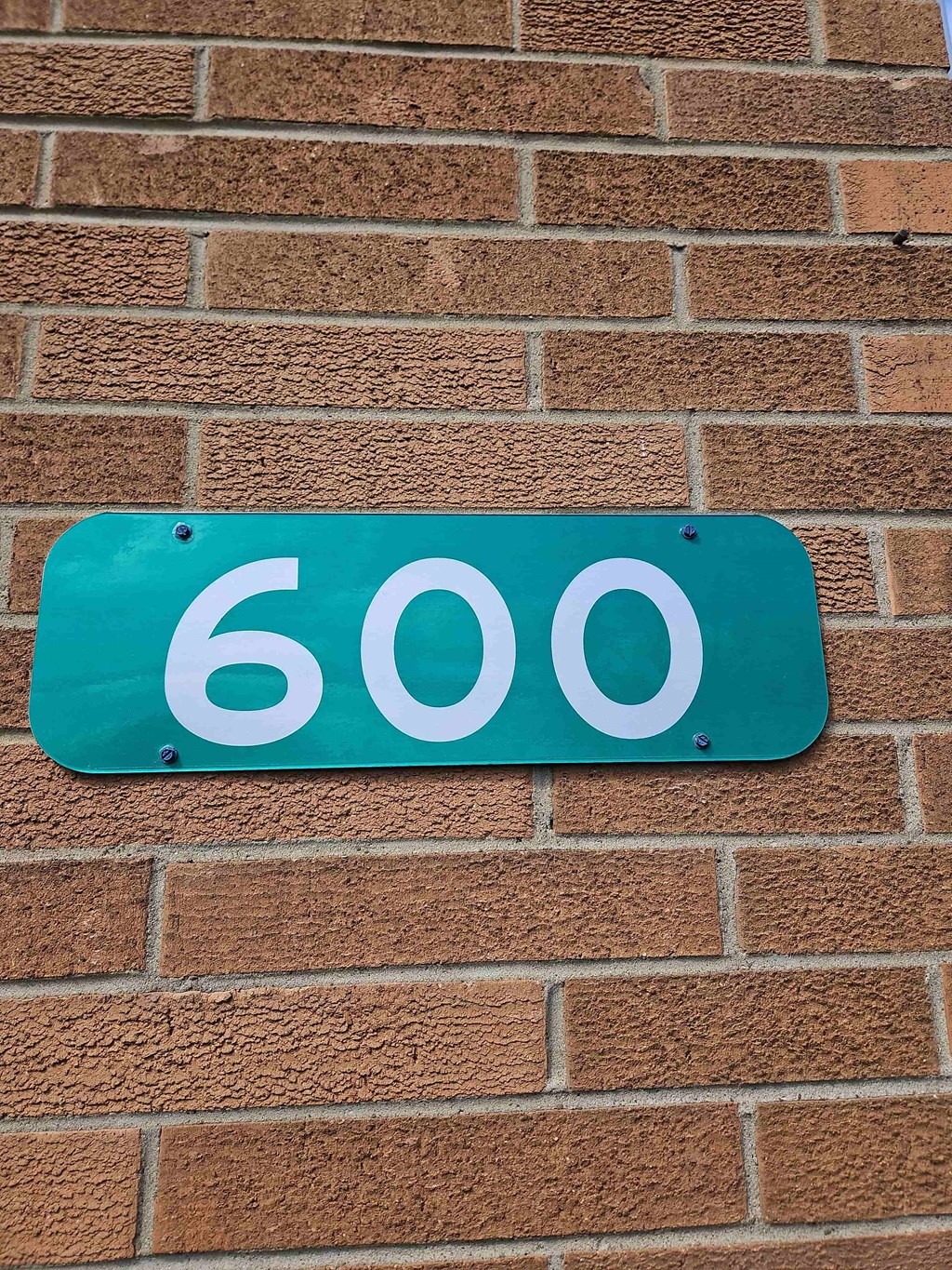 a blue sign with the number 60 on a brick wall