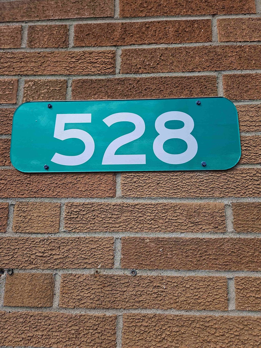 a blue sign with the number 5228 on a brick wall