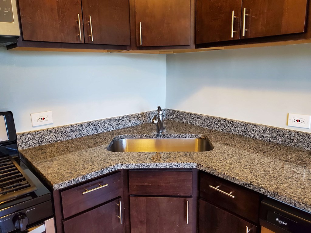 a kitchen with granite counter tops and a stainless steel sink