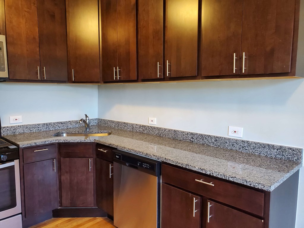 a kitchen with a granite counter top and wooden cabinets