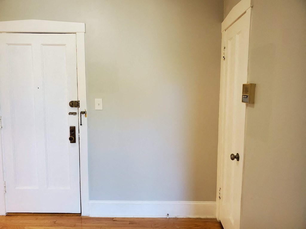 an empty room with two white doors and a wood floor