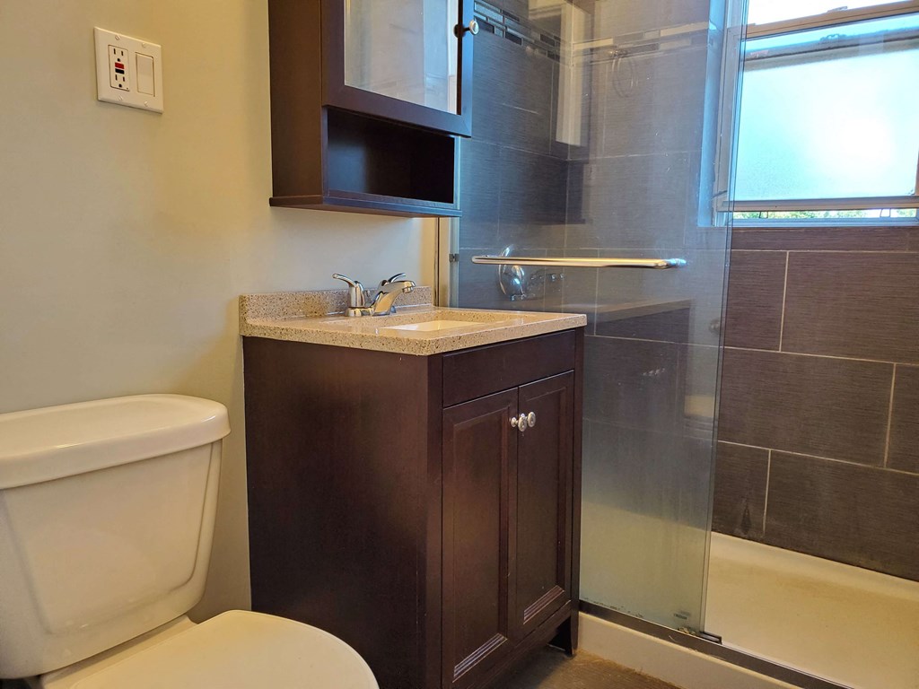a bathroom with a toilet and a sink and a shower