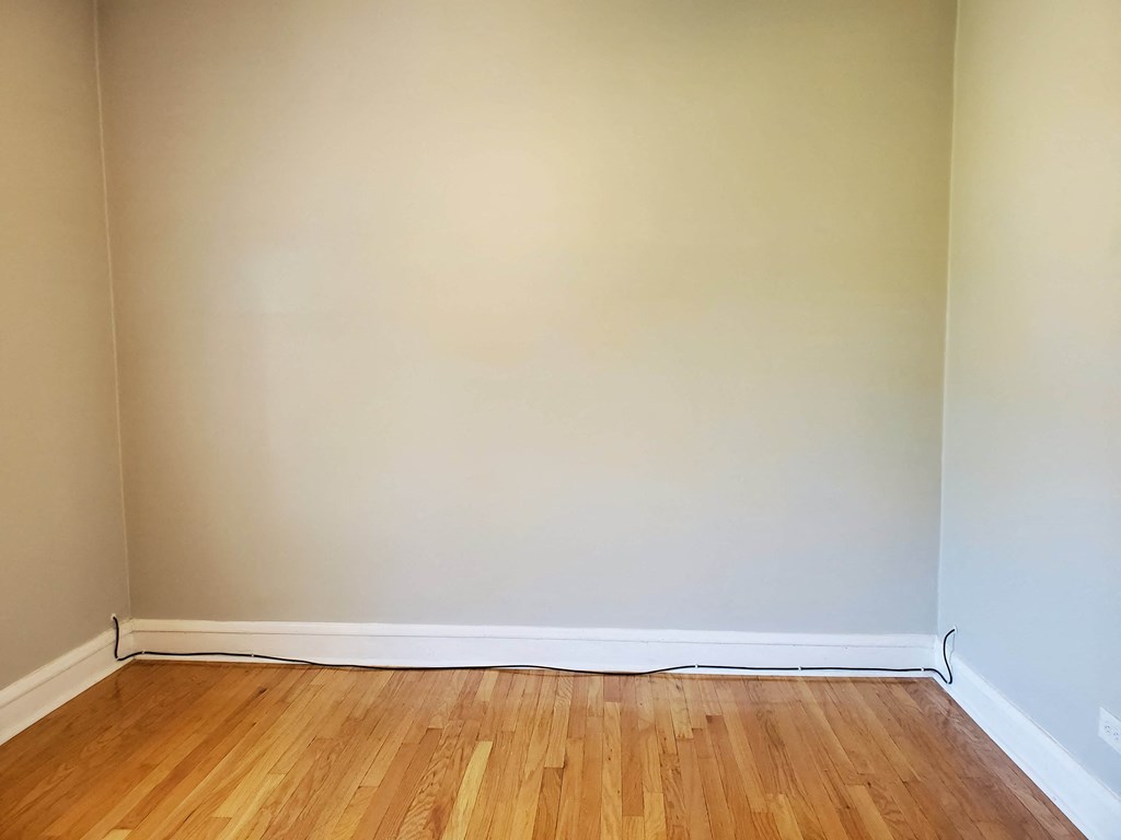 an empty room with white walls and wooden floors