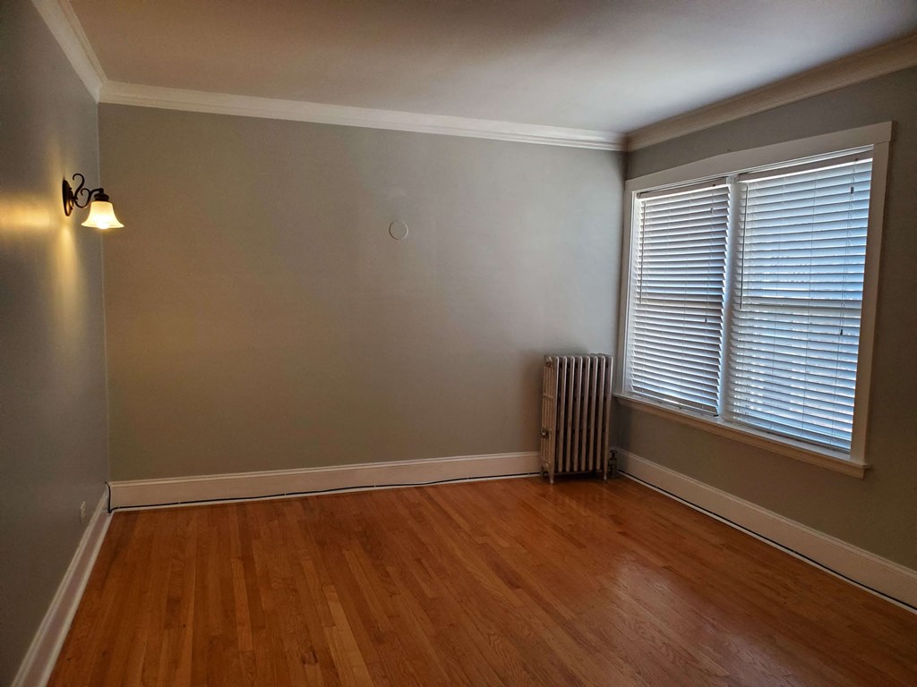 the living room of an empty house with wood floors and a window