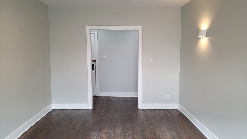 a living room with wood flooring and a white door