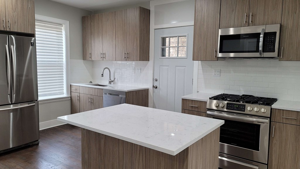 a kitchen with a marble counter top and stainless steel appliances
