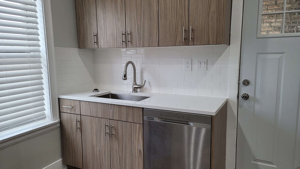 a small kitchen with wooden cabinets and a sink