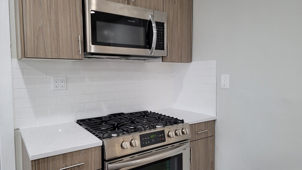 an empty kitchen with a stove and a microwave