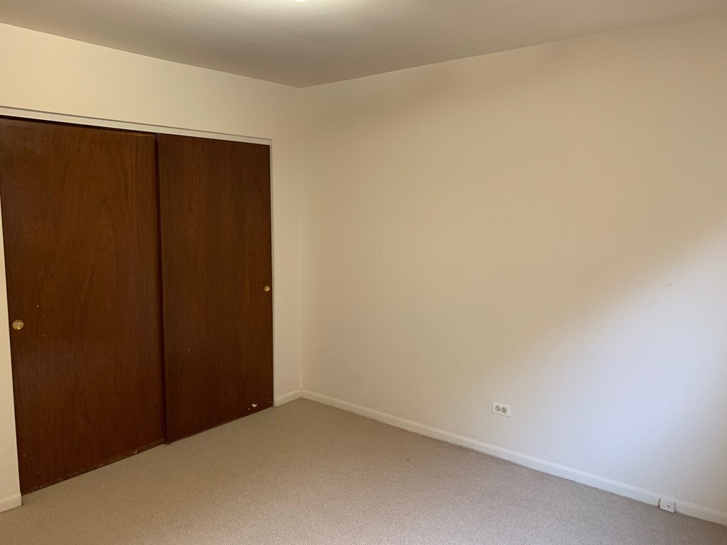 a bedroom with a wardrobe and a carpeted floor