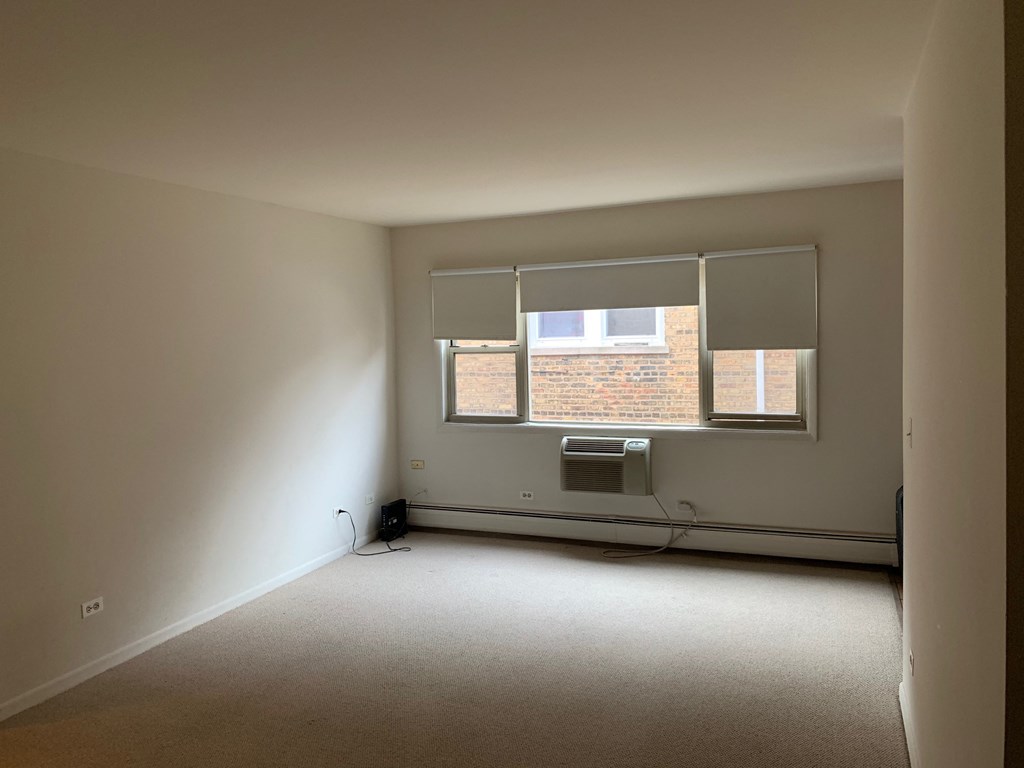 an empty room with a window and a radiator in it