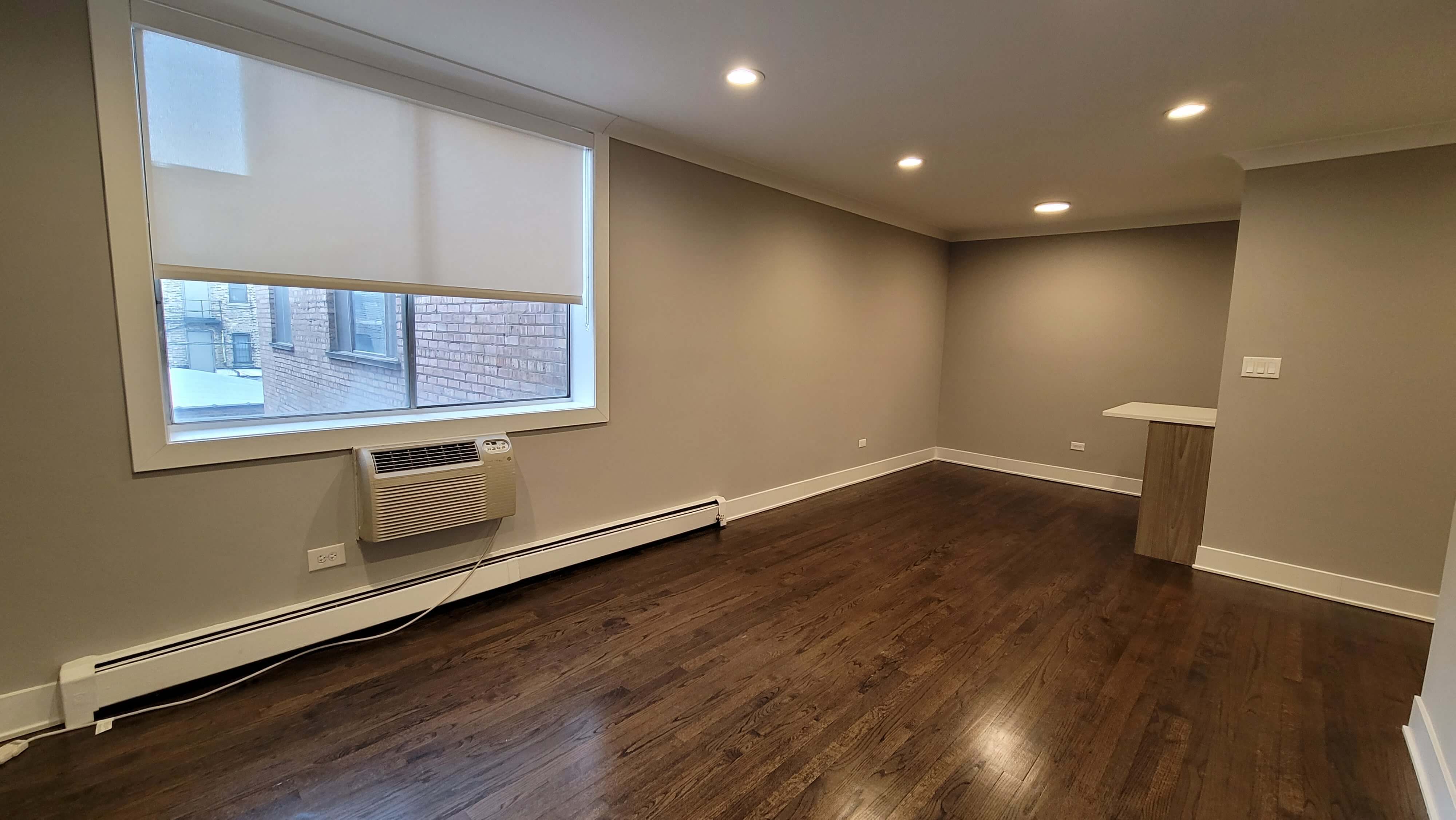 a living room with wood floors and a large window